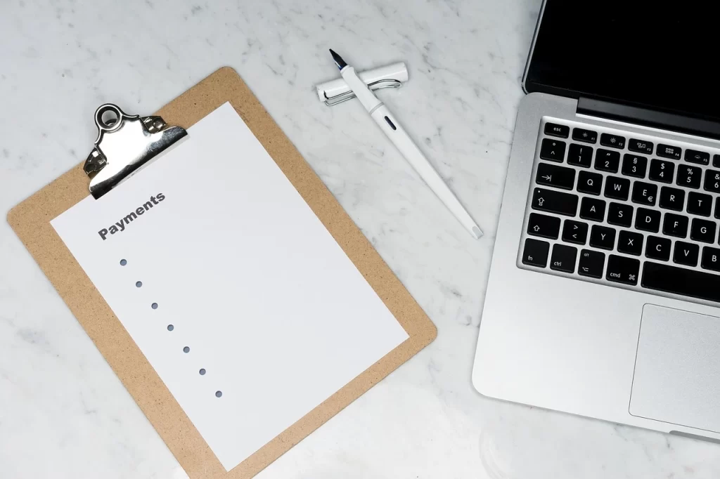 A notebook, a pen and a lap top, presumably used the calculate the cost of commercial surrogacy  
