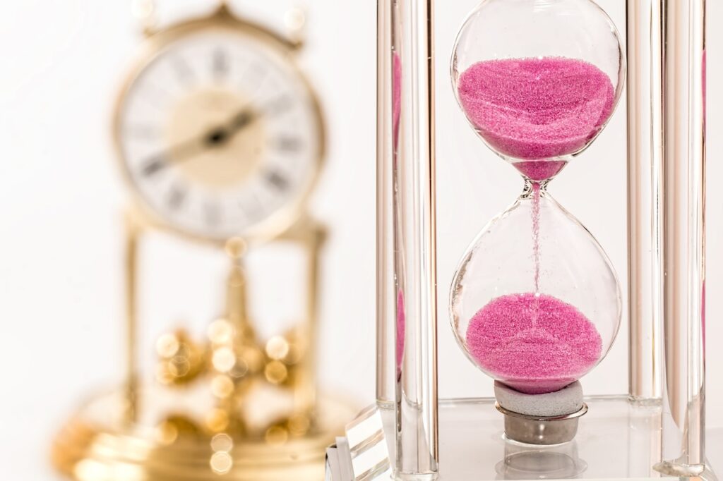a regular clock and an hourglass indicating the passage of time